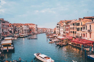 Boats in canal amidst buildings in city