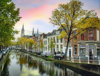 Canal amidst buildings against sky in city