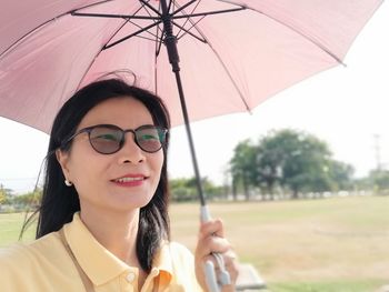 Woman holding umbrella while standing outdoors