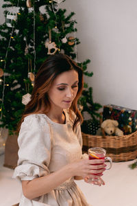 New year's drink in the hands of a young woman in a white sweater.