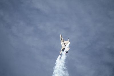 Low angle view of airplane flying against sky