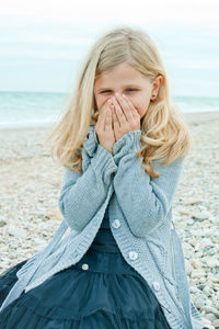 Portrait of young woman standing at beach