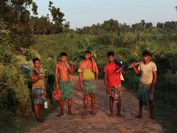 Group of people standing against mountain.