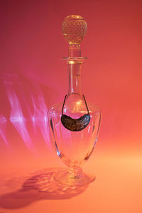 Close-up of water bottle on table against red background