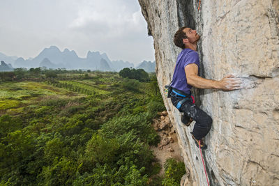 Man climbing on the limestone cliff "white mountain" in yangshuo