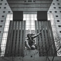 Low angle view of statue against building in city