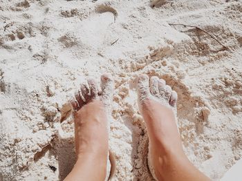 Low section of person standing on sand