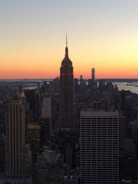 Empire state building with cityscape against sky during sunset