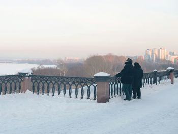 A couple of people at the embankment in winter