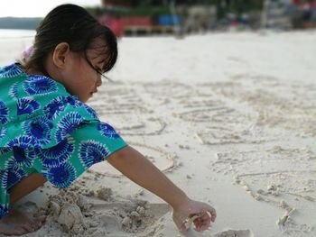 Cute girl playing on sand at beach