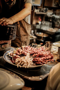 Midsection of man preparing food at market stall