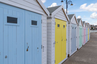 Beach huts in a row at the beach with multi coloured doors