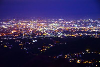 High angle view of illuminated buildings against sky at night