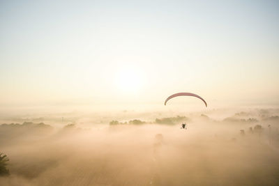 Person paragliding against sky