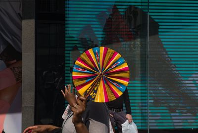 Low section of people holding multi colored umbrella