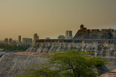 Buildings in city against sky during sunset