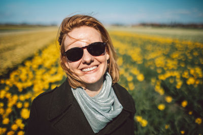 Portrait of a smiling young woman in a narcissus field 