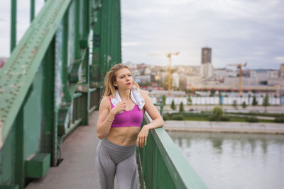 Full length of woman standing on bridge over city