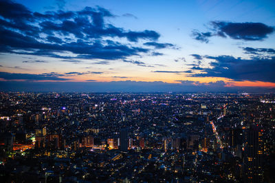 Illuminated cityscape against sky at night