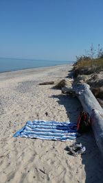Scenic view of beach against clear blue sky