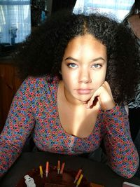 Portrait of beautiful woman with birthday cake at home