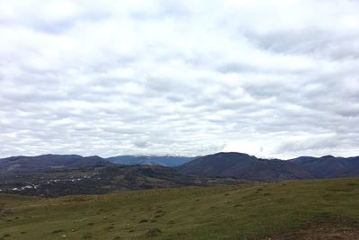 Scenic view of mountains against cloudy sky