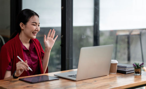 Young businesswoman using laptop on table