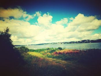 Scenic view of calm lake against cloudy sky