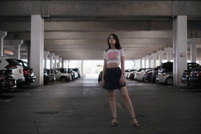 Full length portrait of woman standing in parking lot