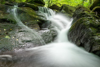 Long exposure of a waterfall on the river flowing through the woods at watersmeet in exmoor