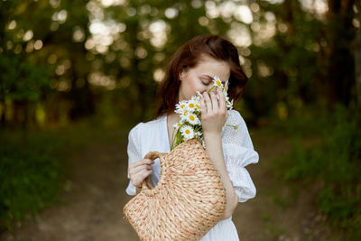 Young woman blowing flowers