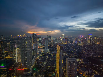 High angle view of illuminated cityscape against sky at night