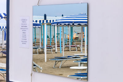 Empty chairs and tables against clear blue sky