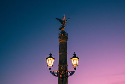 Low angle view of statue on column against sky during sunset