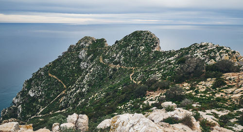 Rocks on sea shore against sky