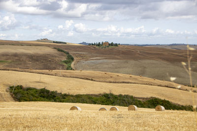 Hay bales on field against sky