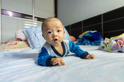 Portrait of cute boy lying on bed