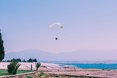 People flying over sea against sky