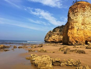 Rock formation on beach against sky