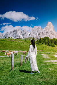 Woman standing on field against sky