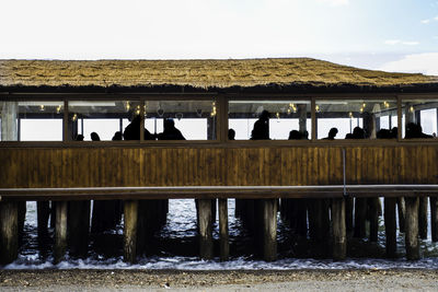 People standing by lake against sky