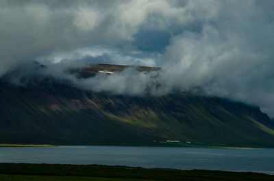 Scenic view of sea and mountains against sky