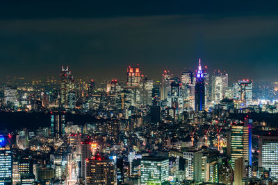Illuminated cityscape against sky at night