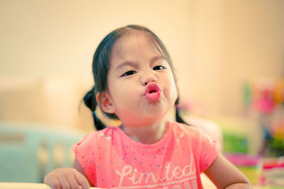 Portrait of cute girl puckering at home