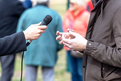 Journalist making media or vox pop interview with unrecognizable person