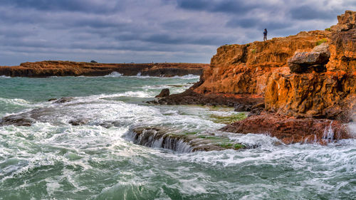 Scenic view of rocks in sea against sky