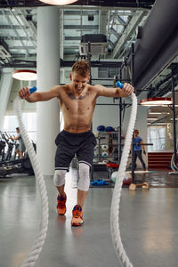 Portrait of young woman exercising in gym