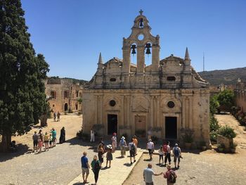 High angle view of people at historic church against clear blue sky