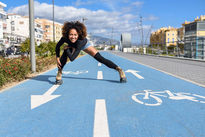 Portrait of woman roller skating on bicycle lane in city
