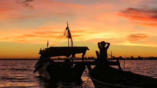 Silhouette boat in sea against sky during sunset